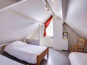 - une chambre mansardée avec 2 lits et une fenêtre dans l'établissement Holiday Home Buitenplaats Gerner-8 by Interhome, à Dalfsen