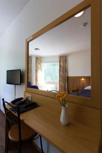 a mirror in a hotel room with a desk with a computer at Hotelli Pesti in Parkano