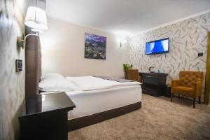 a bedroom with a bed and a desk and a tv at ŽAD Apartments and Rooms in Banja Luka