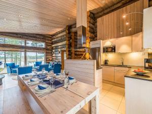 eine Küche und ein Esszimmer mit einem Tisch und blauen Stühlen in der Unterkunft Holiday Home Jussis chalet b by Interhome in Kuusamo