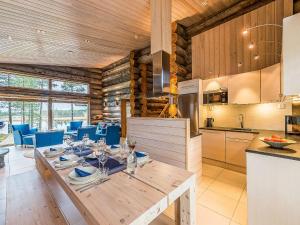 a kitchen and dining room with a table and blue chairs at Holiday Home Jussis chalet b by Interhome in Kuusamo