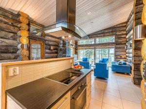 a kitchen with wooden walls and a stove top oven at Holiday Home Jussis chalet b by Interhome in Kuusamo