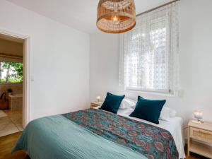 a bedroom with a large bed with blue pillows at Holiday Home Rayon de soleil by Interhome in Carnac