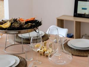 a table with wine glasses and a plate of food at Holiday Home Rayon de soleil by Interhome in Carnac +16 photos
