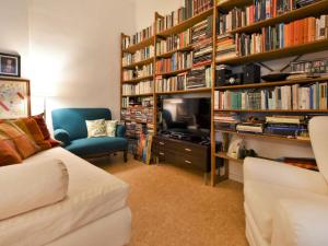 ein Wohnzimmer mit einem Sofa, einem TV und Bücherregalen in der Unterkunft Apartment NoLo Art Apartment by Interhome in Mailand