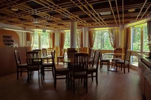 a dining room with tables and chairs and windows at Hotelli Pesti in Parkano