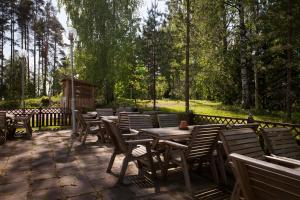 a group of wooden tables and chairs on a patio at Hotelli Pesti in Parkano