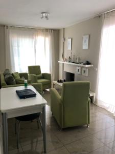 sala de estar con sillas verdes y mesa en Ático Los Rombos, en Puerto Naos