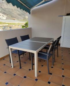 una mesa y sillas en una habitación con vistas en Ático Los Rombos, en Puerto Naos
