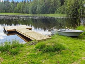 a boat on the shore of a lake with a dock at Holiday Home Lietukka by Interhome in Outokumpu +17 photos