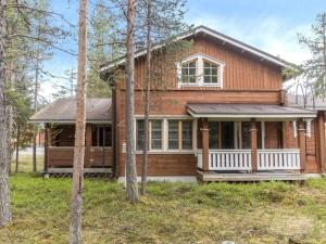 a wooden house with a porch in the woods at Holiday Home Lauri 4 iso by Interhome in Sirkka