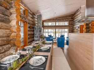 a dining room with a long table and blue chairs at Holiday Home Jussis chalet a by Interhome in Kuusamo +18 photos