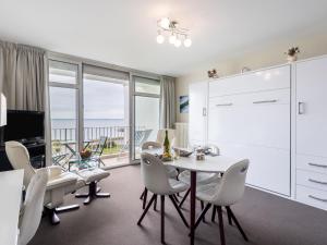 a living room with a white table and chairs and a large window at Apartment Les Trois Iles-9 by Interhome in Quiberon