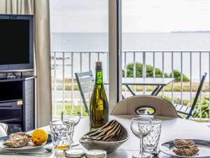 un tavolo con una bottiglia di vino e bicchieri di Apartment Les Trois Iles-9 by Interhome a Quiberon