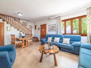 una sala de estar con sofás azules y una mesa. en Holiday Home Pintor Beach House by Interhome, en Puerto Pollensa