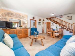 Holiday Home Pintor Beach House by Interhome في بورت دي بوينسا: غرفة معيشة مع أريكة زرقاء وطاولة