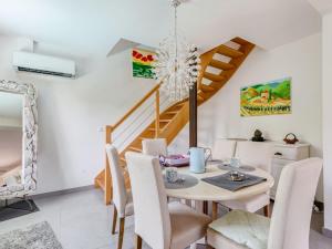 un comedor con mesa y sillas y una escalera en Holiday Home Les Nanous by Interhome en Saint-Raphaël