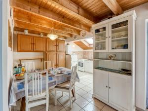 a kitchen with white cabinets and a table and chairs at Holiday Home Ker Kébec by Interhome in Crozon