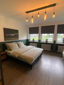 ein Schlafzimmer mit einem großen Bett in einem Zimmer mit Fenstern in der Unterkunft Waldhaus Kustelberg in Medebach