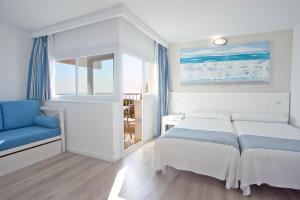 a bedroom with a bed and a blue chair at HYB Eurocalas in Calas de Mallorca