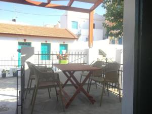 Une table et des chaises en bois sont disponibles sur la terrasse. dans l'établissement Kontos-Traditional house in Andros beach, à Andros
