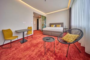 pokój hotelowy z łóżkiem i krzesłami w obiekcie Hotel Hertz w mieście Hradec Králové