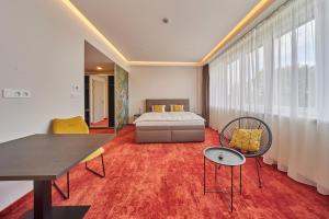 sypialnia z łóżkiem, stołem i krzesłami w obiekcie Hotel Hertz w mieście Hradec Králové