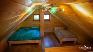 a room with two beds in a wooden cabin at Glamping Vrhovc in Železniki