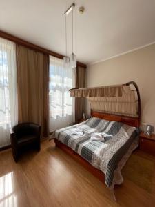 1 dormitorio con 1 cama y 1 silla en Hotel City en Gniezno