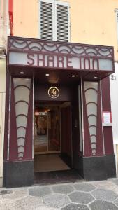 einen schattigen Eingang zu einem Gebäude mit einem Schild darauf in der Unterkunft Residence Share Inn in Nizza