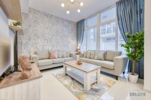 a living room with a couch and a table at Opulent 3BR Townhouse at DAMAC Hills 2 Dubailand by Deluxe Holiday Homes in Dubai