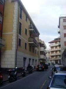 a city street with a building and cars on the road at Dimora Tipica Appartamento in Sestri Levante