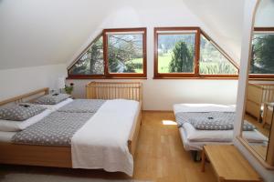 a bedroom with two beds and two windows at Villa Schnuck - das rote Ferienhaus in Bad Gastein