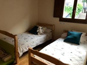 two beds in a room with a teddy bear on it at Casa adosada familiar con jardín y piscina in Villanúa