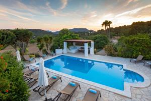 a swimming pool with chairs and a gazebo at Villa Near Ibiza Town - San Antonio Sleeps 14 in San Jose