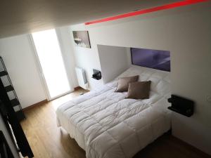a bedroom with a white bed with a red stripe on the wall at V&Spa 2 chambres d'hôtes avec Spa privatif dont une avec un Sauna in Saint-Martin-Boulogne