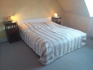 Bett in einem Zimmer mit zwei Nachttischen und zwei Lampen in der Unterkunft Gästewohnung SEETOR in Lenzen