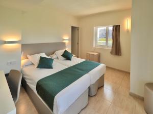una camera da letto con un grande letto bianco con cuscini verdi di BQ Belvedere Hotel a Palma de Mallorca
