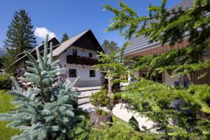 dom z choinką przed nim w obiekcie Apartments Alp w Bohinju