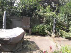 a garden with a cover over a bench and some bushes at RAJ Living - 1 , 2 and 3 Room Monteur Apartments in Duisburg