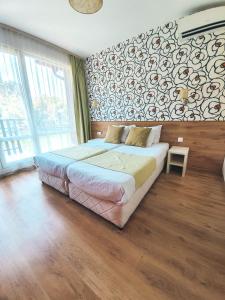 a bedroom with a large bed and a wall of windows at Waterside Houses in Ognyanovo