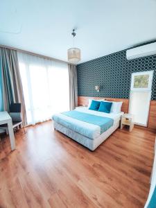 a bedroom with a large bed with blue pillows at Waterside Houses in Ognyanovo