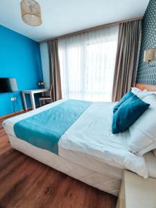 a bedroom with a large bed with blue walls at Waterside Houses in Ognyanovo
