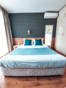 a bedroom with a large bed with blue sheets at Waterside Houses in Ognyanovo