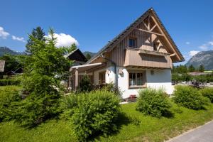 a house with a wooden roof at Apartments Alp in Bohinj