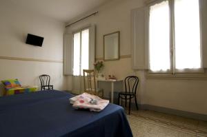Soggiorno Primavera في فلورنسا: غرفة نوم بسرير وطاولة ونوافذ
