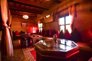 a living room filled with furniture and a fire place at Riad Tamdakhte in Aït Benhaddou