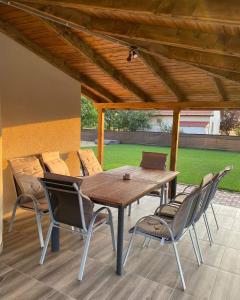 a wooden table and chairs on a patio at Tiszavirág Üdülőház in Kisköre
