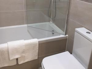 a bathroom with a shower and a toilet and a tub at Showcase Apartments - Kimberley House in Leicester