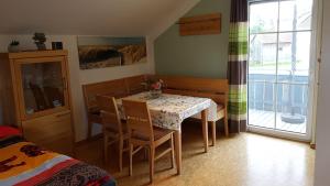 a dining room with a table and chairs and a window at Ferienwohnung Robl in Rötz